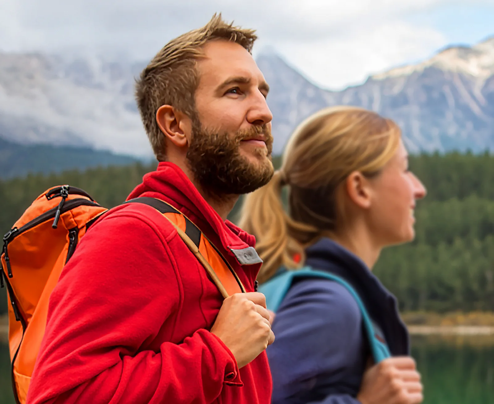 A man and a woman hiking in the mountains, breathing easily