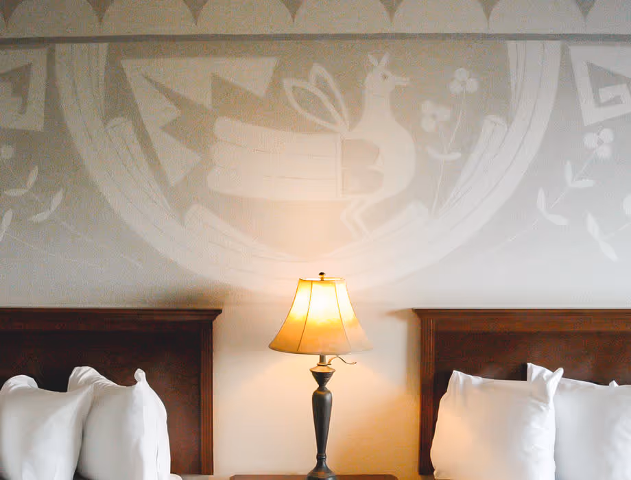 Artist guestroom with mural on the wall with two beds with white bedding