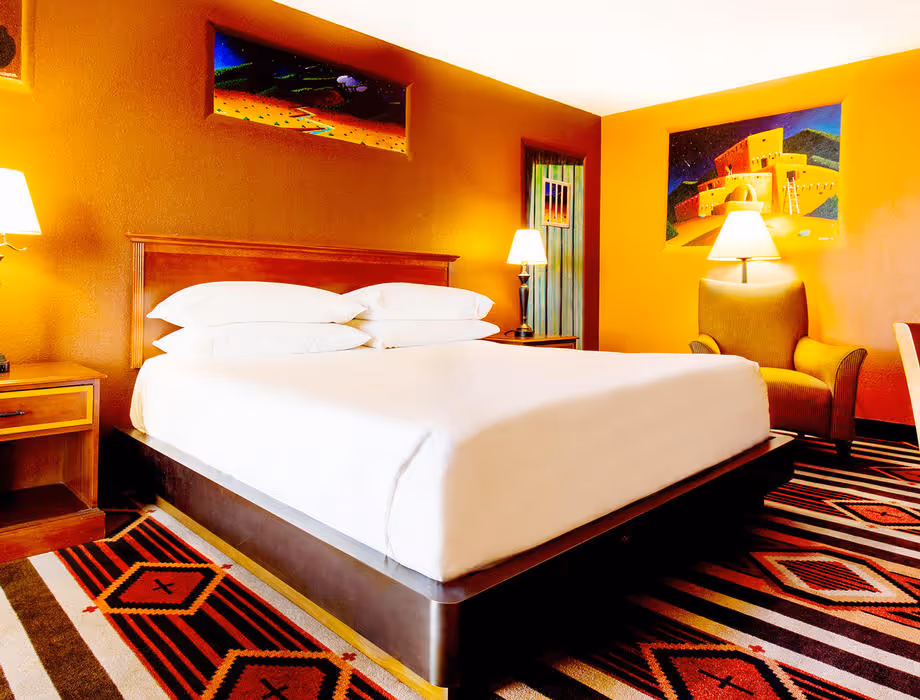 Colorful Artist guestroom with mural on the wall with king bed with white bedding