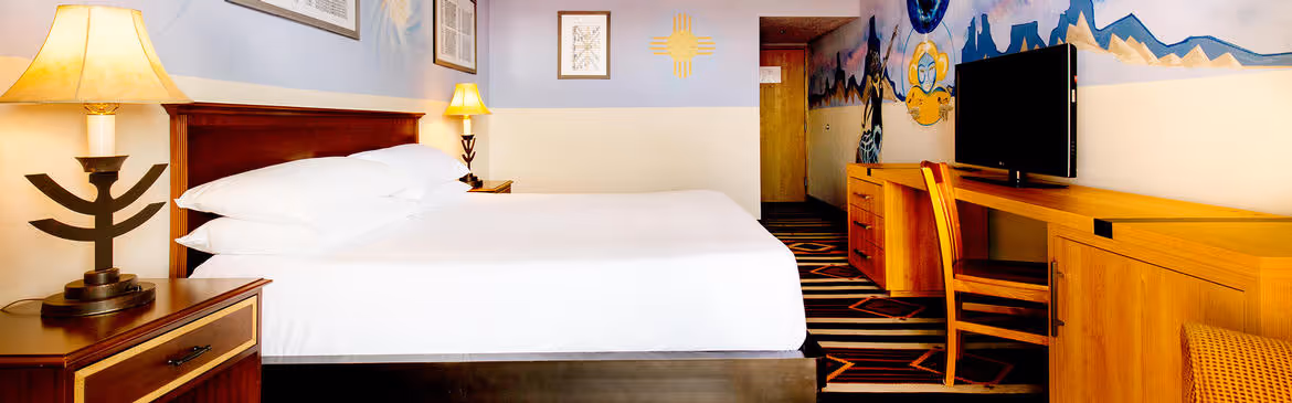 Colorful Artist guestroom with mural on the wall with king bed with white bedding