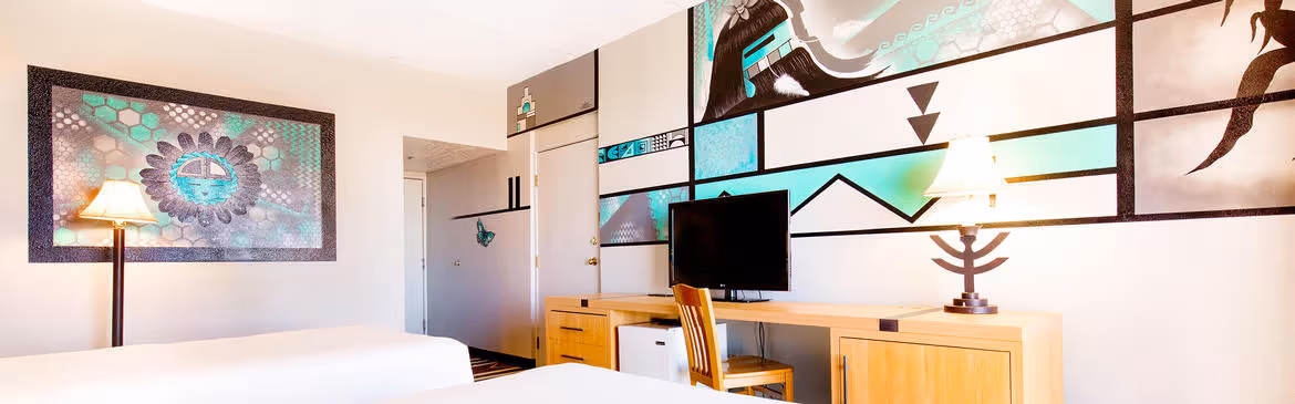 Colorful Artist guestroom with mural on the wall with king bed with white bedding