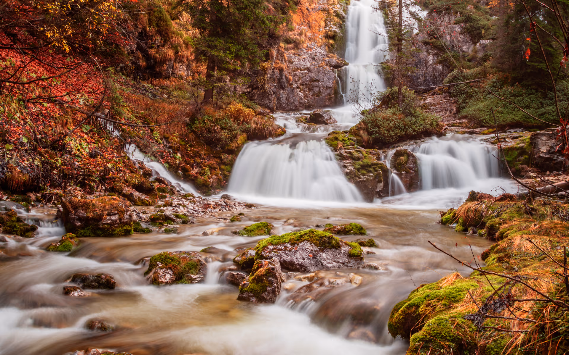 waterfall in mountains with trees in fall