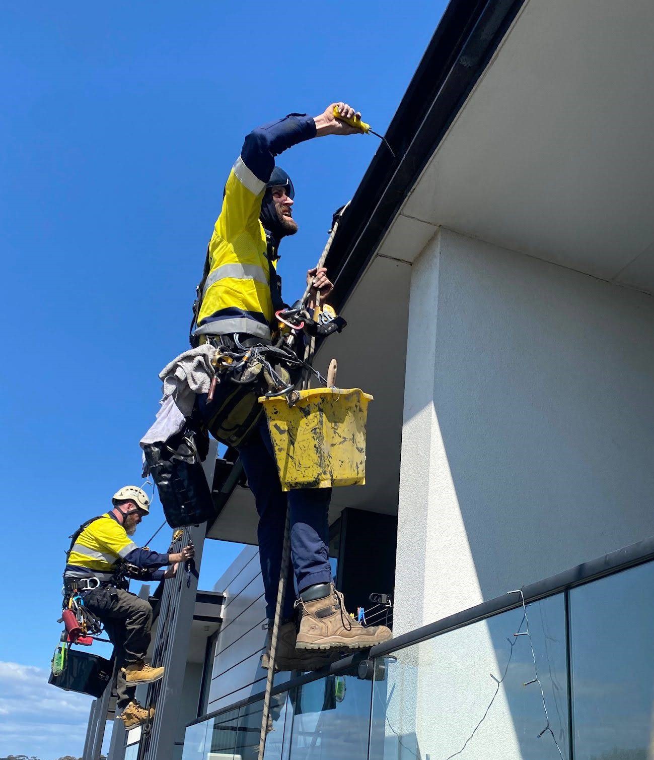IRATA rope access painters repainting a high-rise facade in St Kilda.