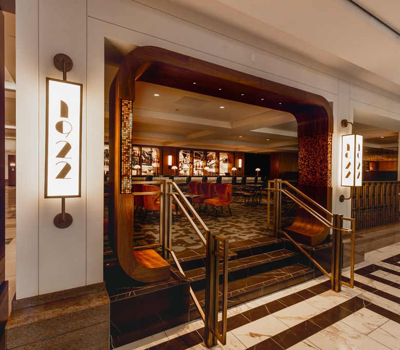 entrance to 1922 Bar dark accents and lighted images of Clyde with airplane behind the bar