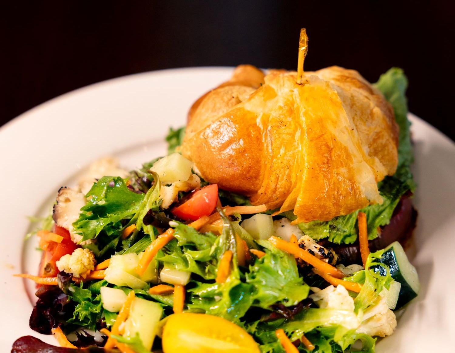 Croissant sandwich with salad on a plate