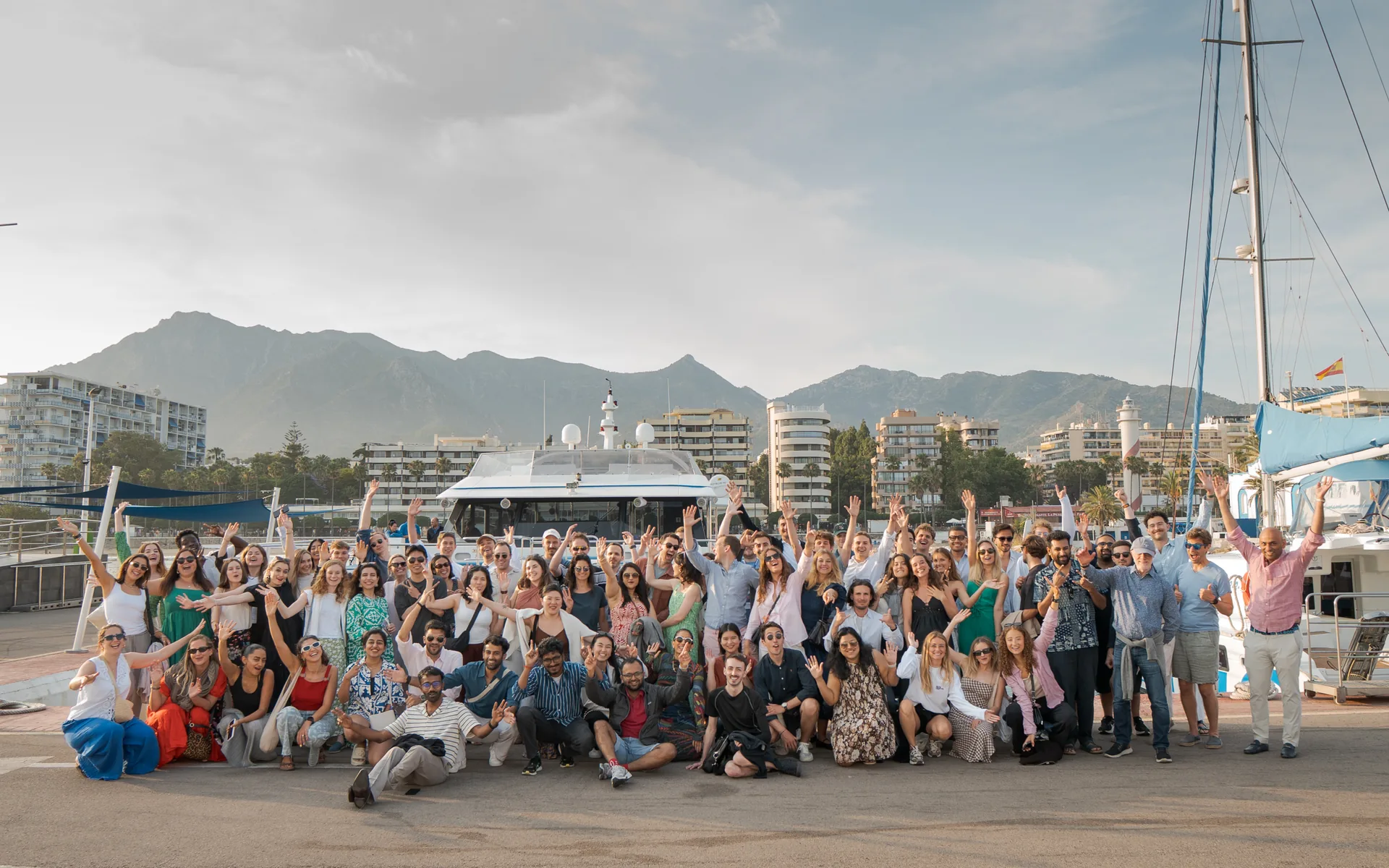 The full OnsiteHub team waving on the marina at sunset in Marbella