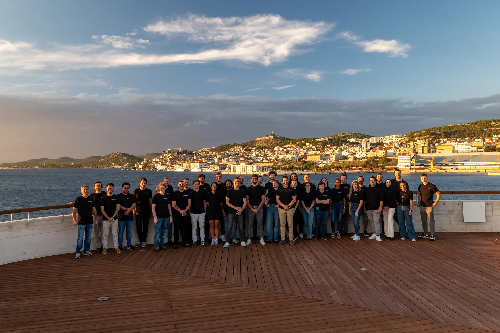 OnsiteHub team together on a waterfront deck at golden hour, Šibenik