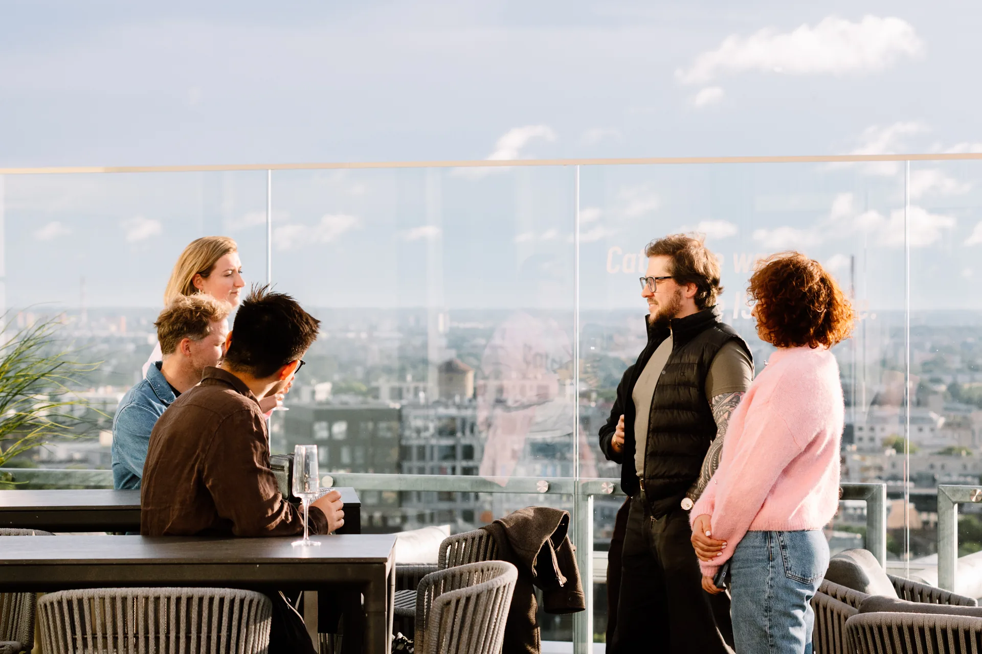 ParkBee colleagues talking on a rooftop terrace with the Tallinn skyline behind them