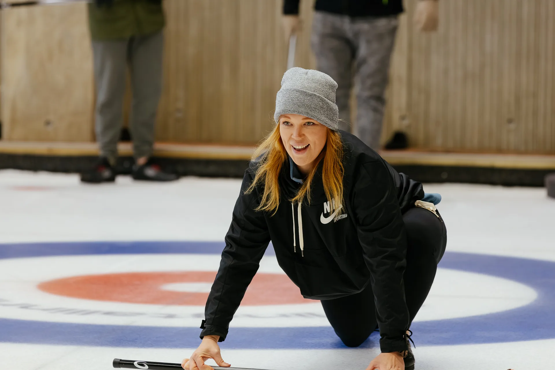 A smiling ParkBee team member on the ice during the curling session