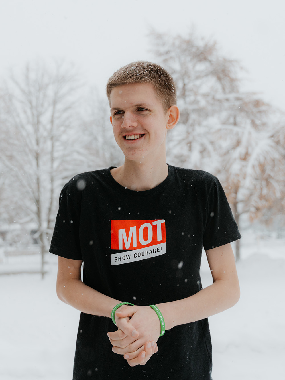 Syver smiler til kamera foran presseveggen til MOT