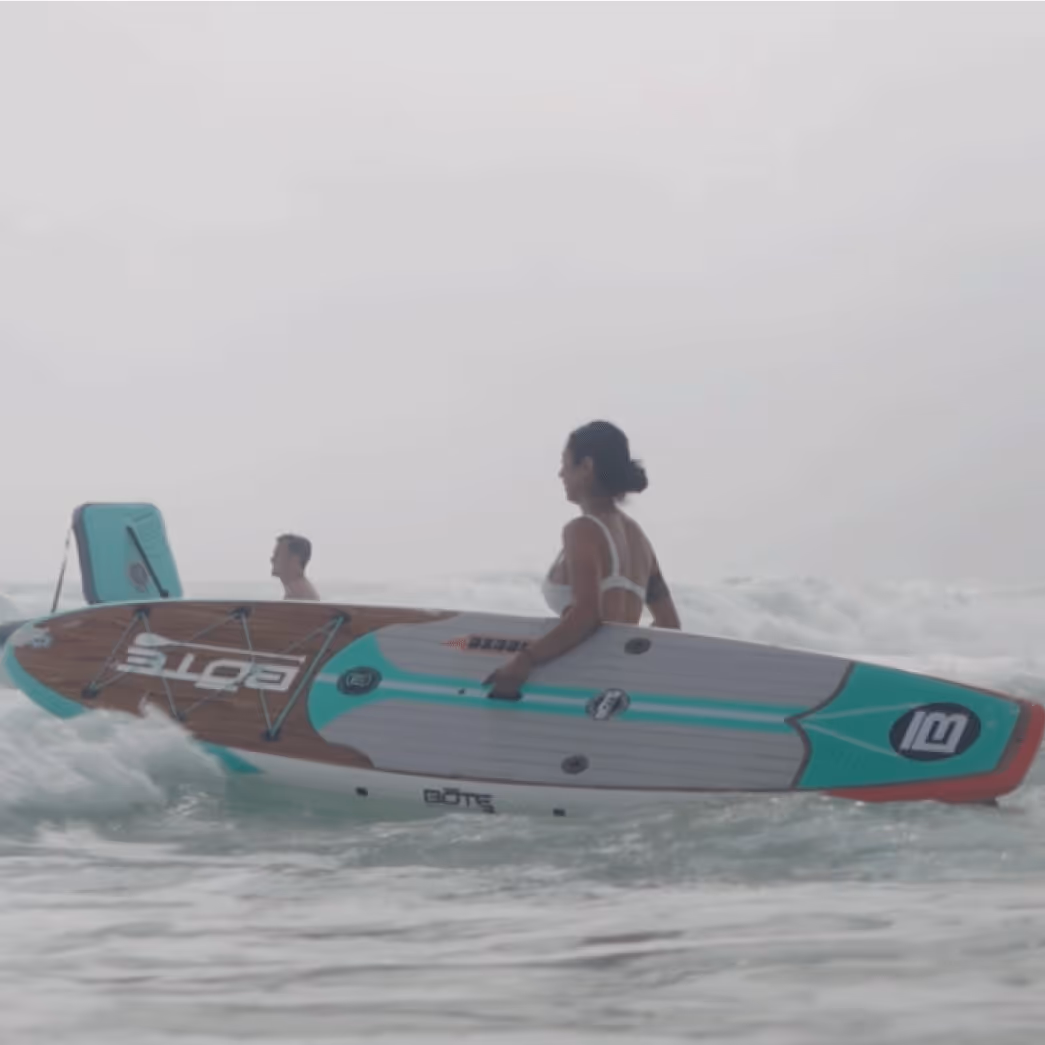 Girl walking into the ocean with paddleboard