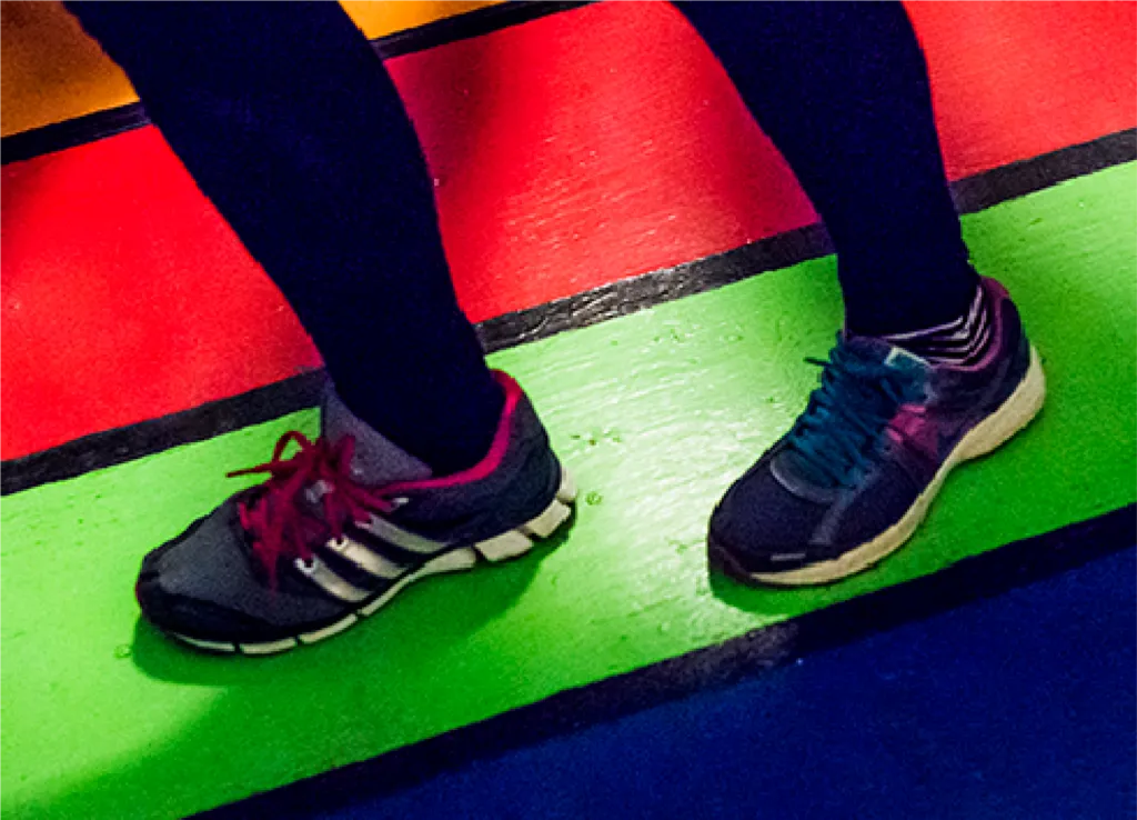 Photo of feet on painted stripes of a floor game.