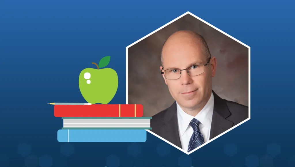 Image of Kenneth Huff, a bald man with glasses wearing a dark suit jacket with white shirt and blue tie. He is framed by a hexagon shape, positioned next to a graphic of three stacked books with a green apple sitting on top.
