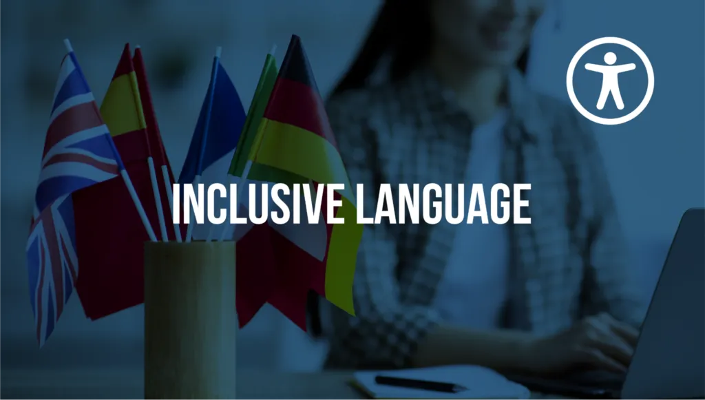 Miniature flags of the United Kingdom, Germany, Spain, and France sit in a cup on a desk. In the background is a woman typing on a computer. In the foreground, "Inclusive Language" is superimposed.