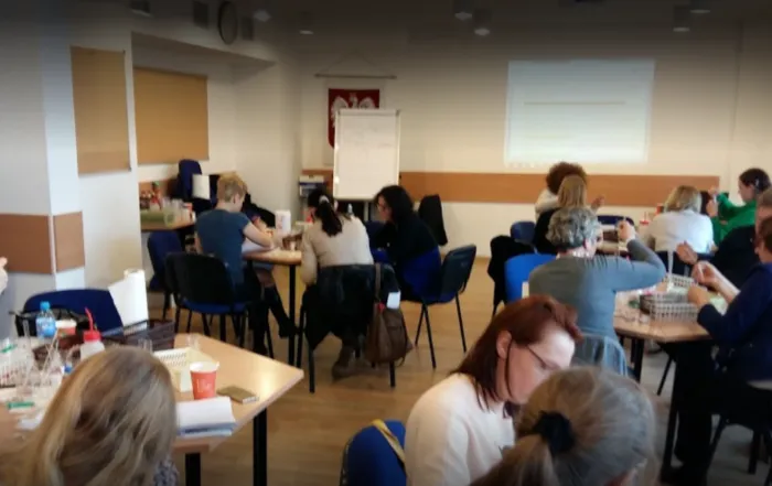 Several groups of science educators sit around tables and complete training tasks at WCIES.