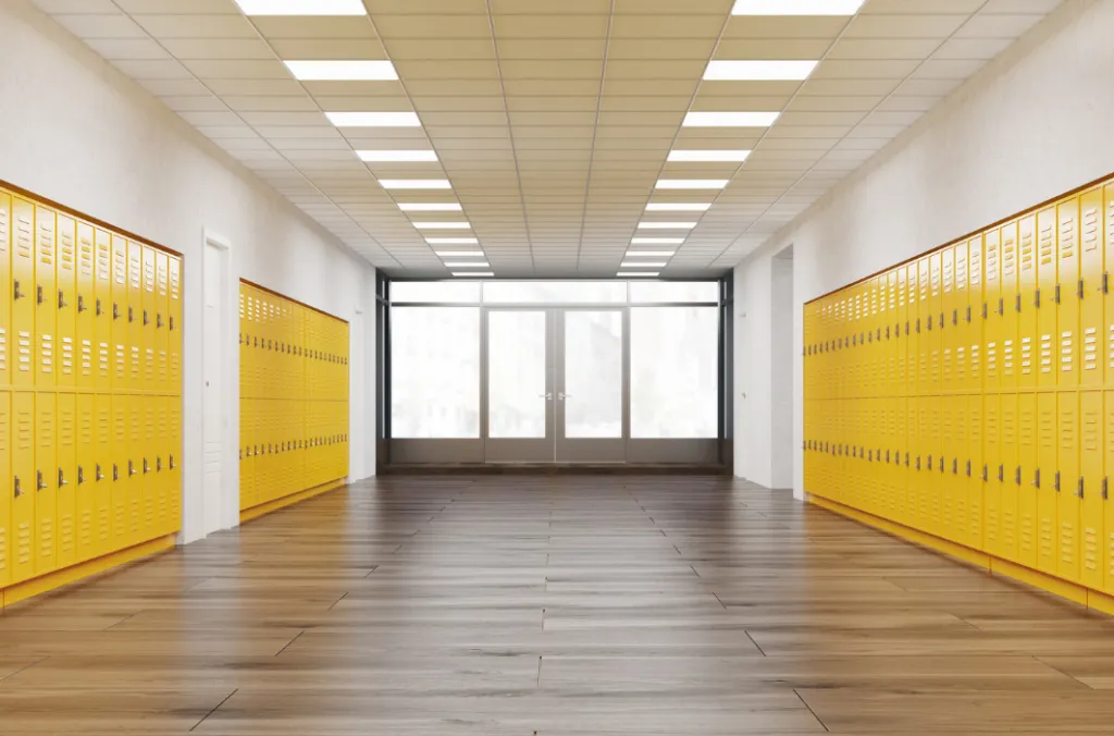 Looking down a long hallway in a school with rows of yellow lockers on either side.