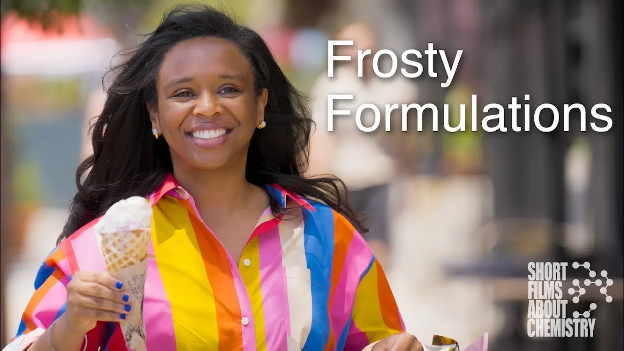 A Black woman with long dark hair wearing a brightly colored striped shirt smiles at the camera while holding an ice cream cone. Next to her is the text "Frosty Formulations" as well as the Chemistry Shorts logo in the bottom right corner. The logo consists of the text "Short films about chemistry" with five dot-and-line models of molecules next to it.)