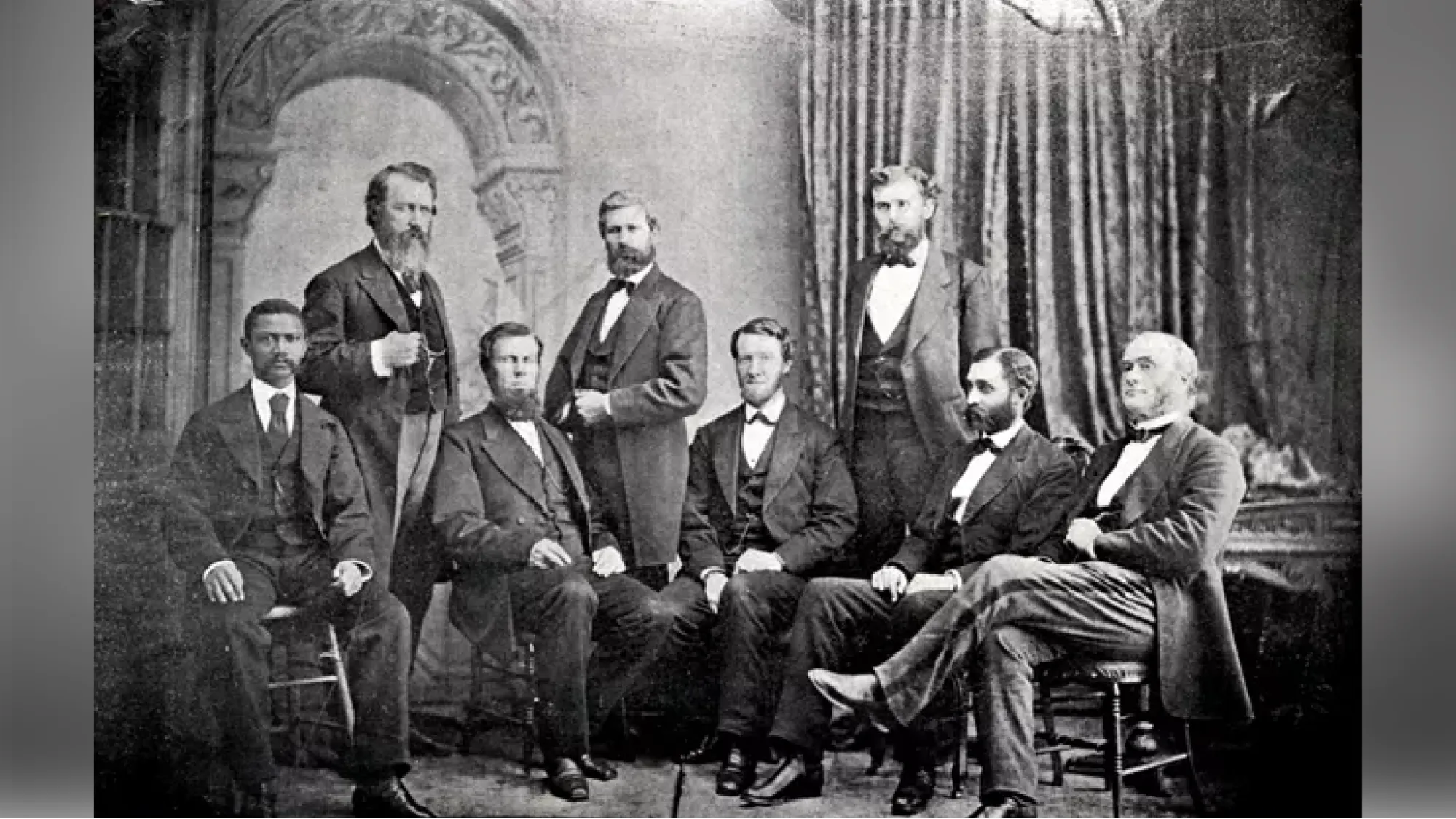  A black and white photograph of eight men (including Dr. Alexander Augusta). Dr. Augusta is the only person of color in the group, the rest are white. All of the men are dressed formally and have serious facial expressions.
