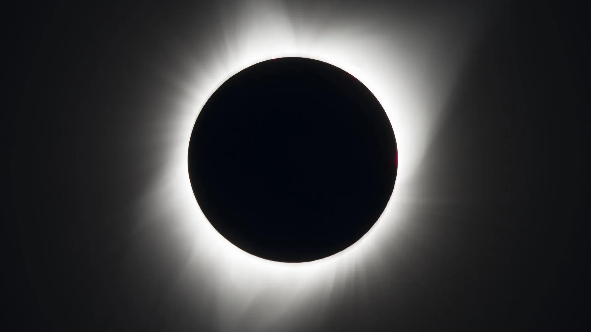 A total solar eclipse, showing the Sun being completely blocked by the Moon, except for the Sun's bright corona, which shines outward around the edge of the Moon.