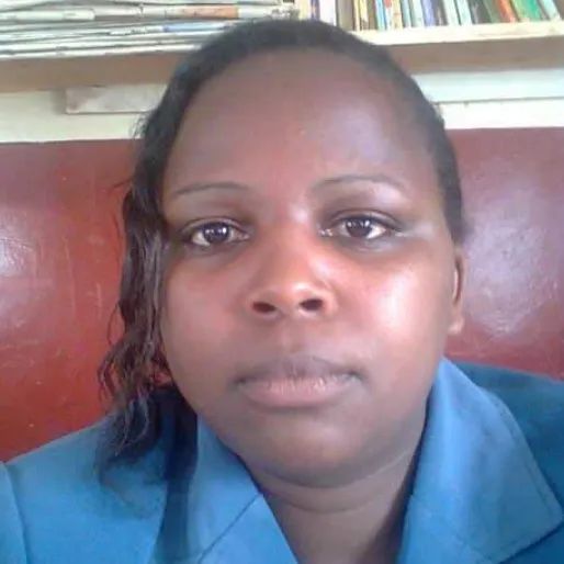 A Black woman with her hair up, wearing a blue blazer.