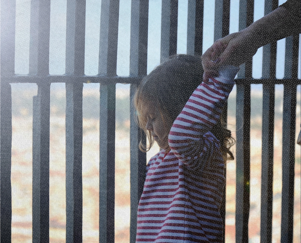 A child standing by a medal fence