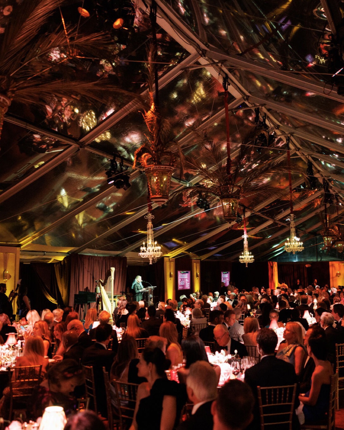 FAMSF Annual Gala under a clear-span tent at the de Young Museum, ceiling washed with floral gobos and crystal chandeliers