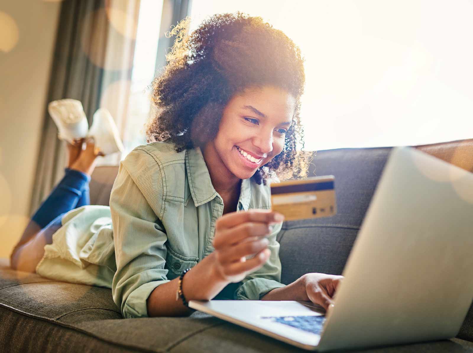 Woman at the computer holding a credit card