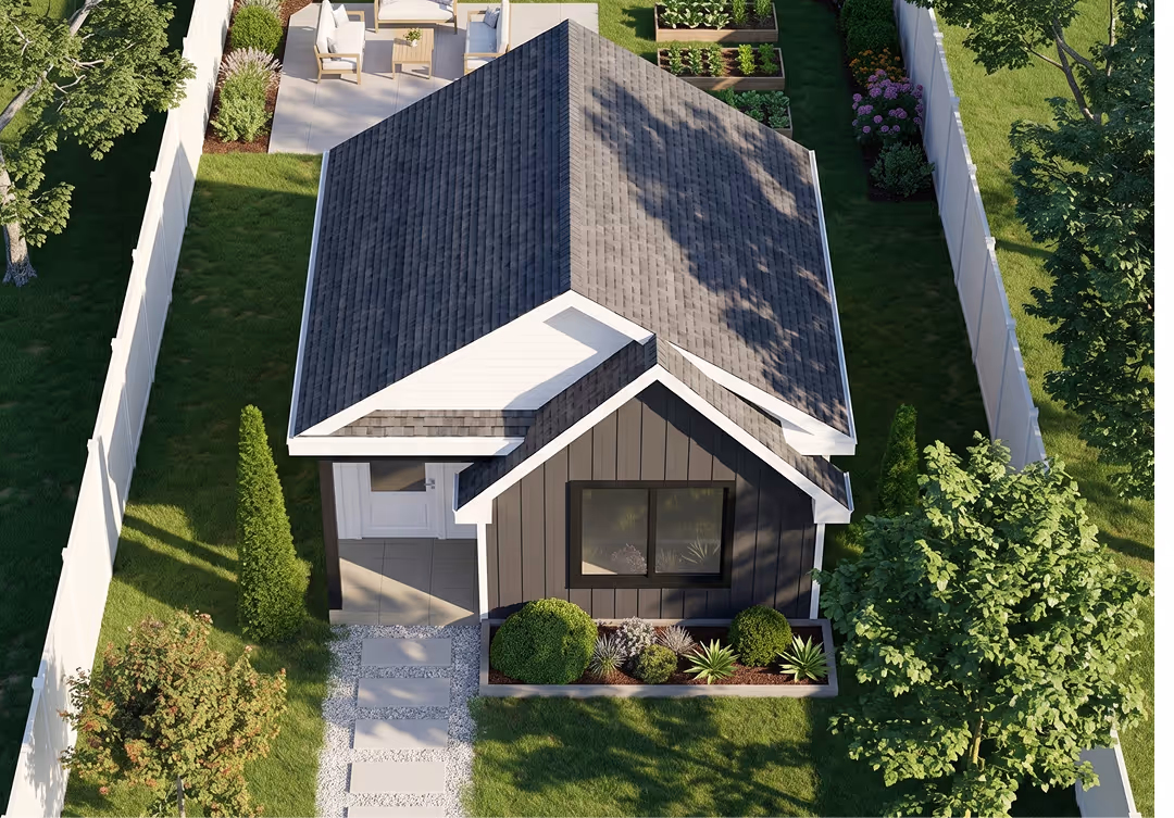 Aerial view of a standalone backyard suite with a dark metal roof nestled among mature trees and landscaping