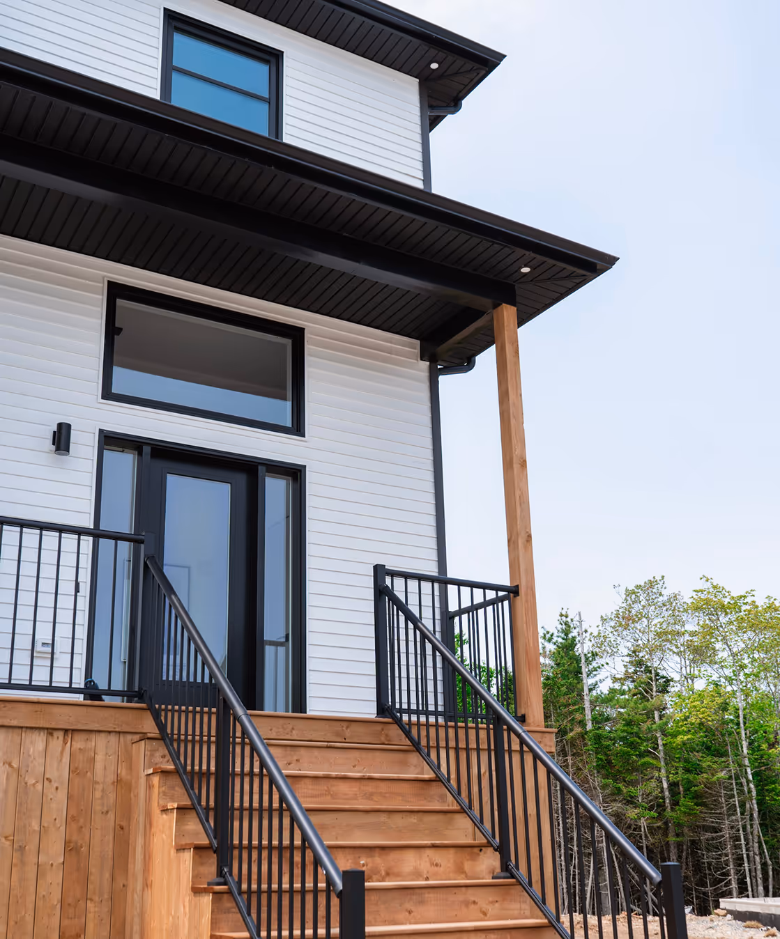 Contemporary eco-friendly home with wooden deck, metal railings, and energy-efficient design in Halifax