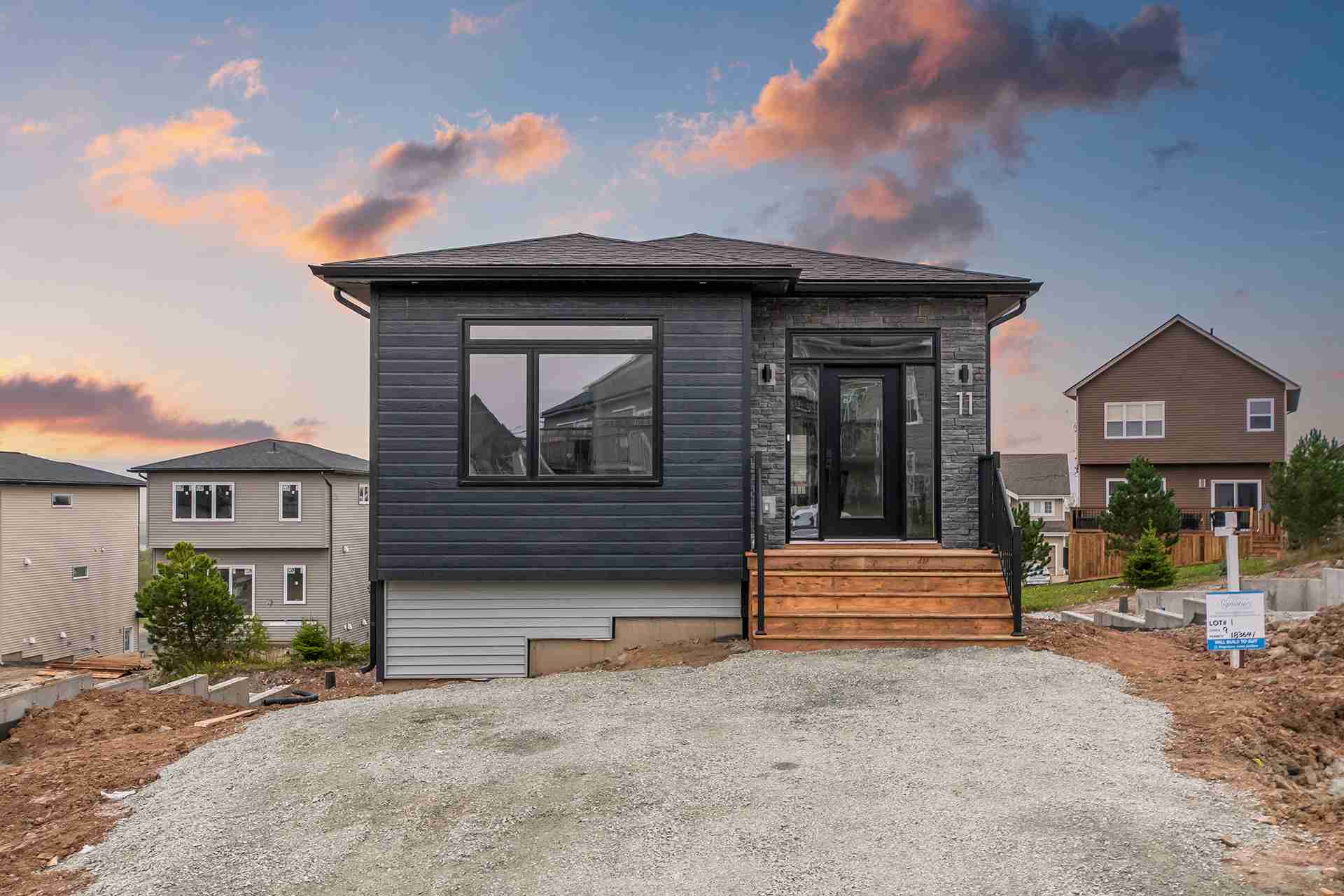 Modern eco-friendly home in Nova Scotia featuring energy-efficient design with dark gray siding, stone accents, and triple-pane windows by Signature Homes