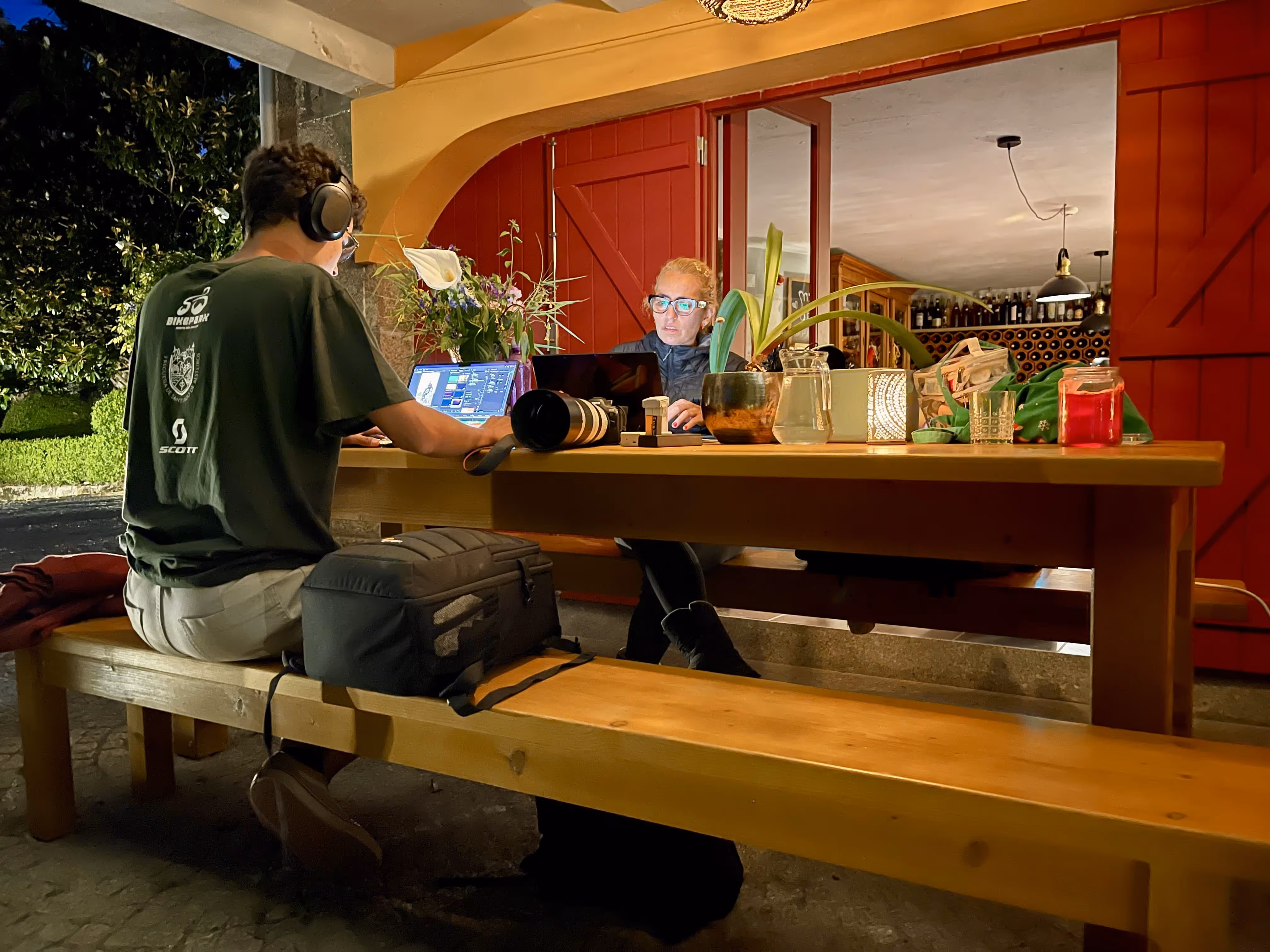 Pessoas a trabalhar com portáteis no terraço da Casa da Seara à noite
