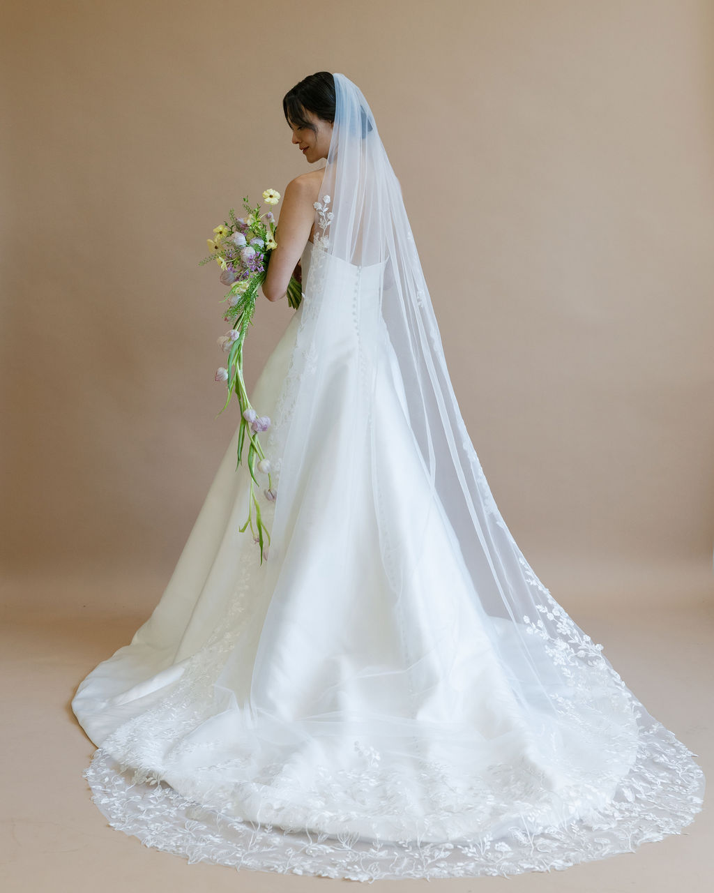 Bride wearing long lace veil 