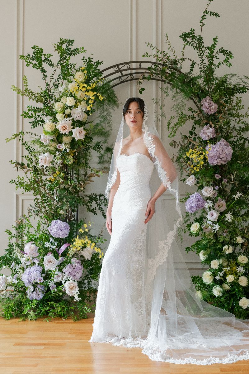 Bride wearing long lace veil 