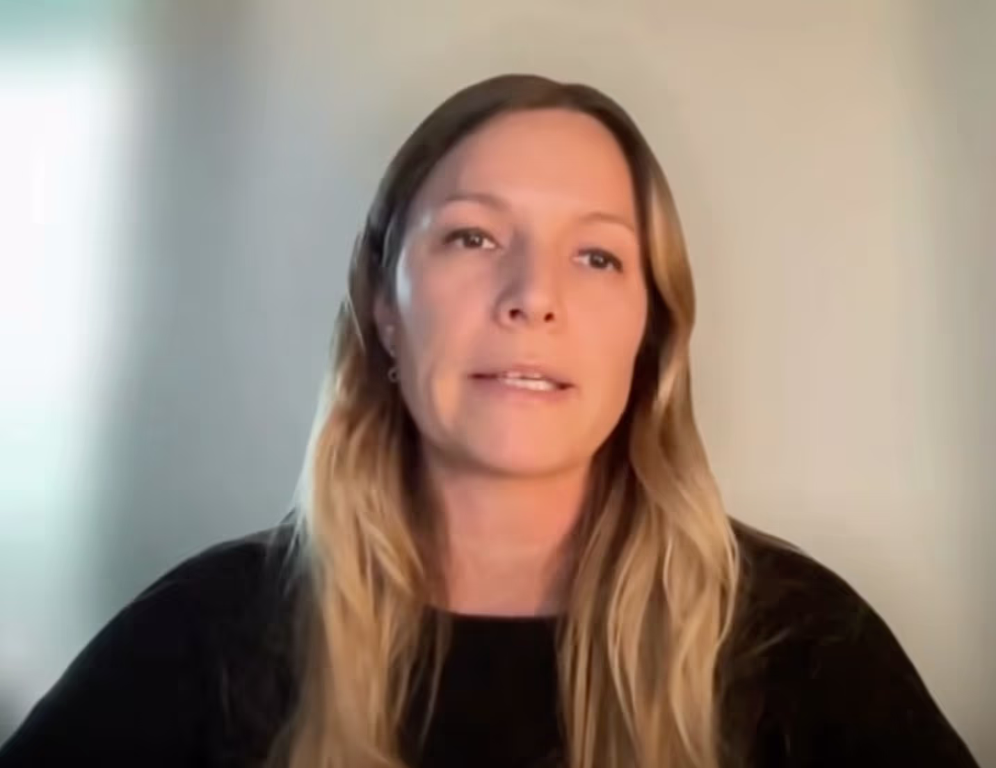 A woman with long hair and a black shirt.