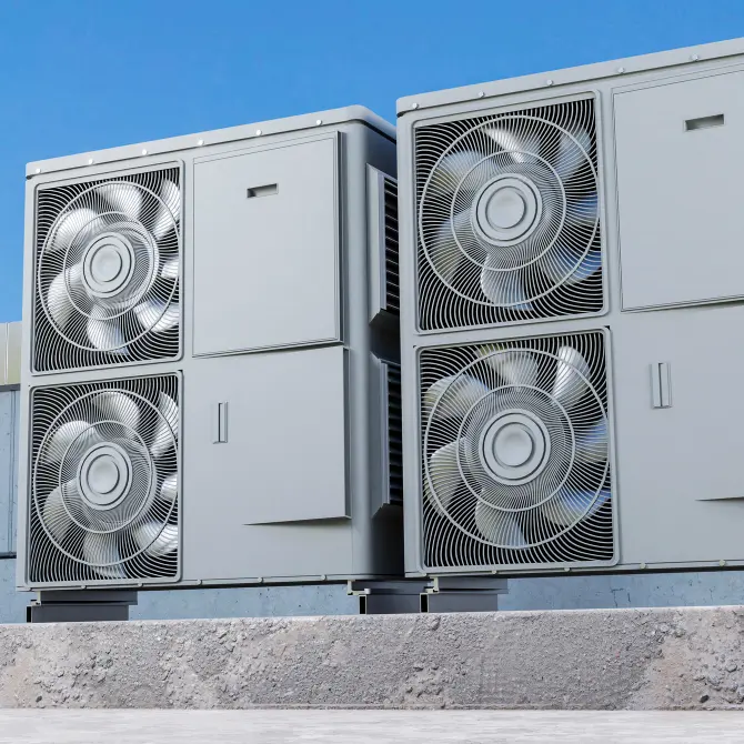 Four large industrial HVAC units with metal fan covers mounted on a rooftop against a blue sky.