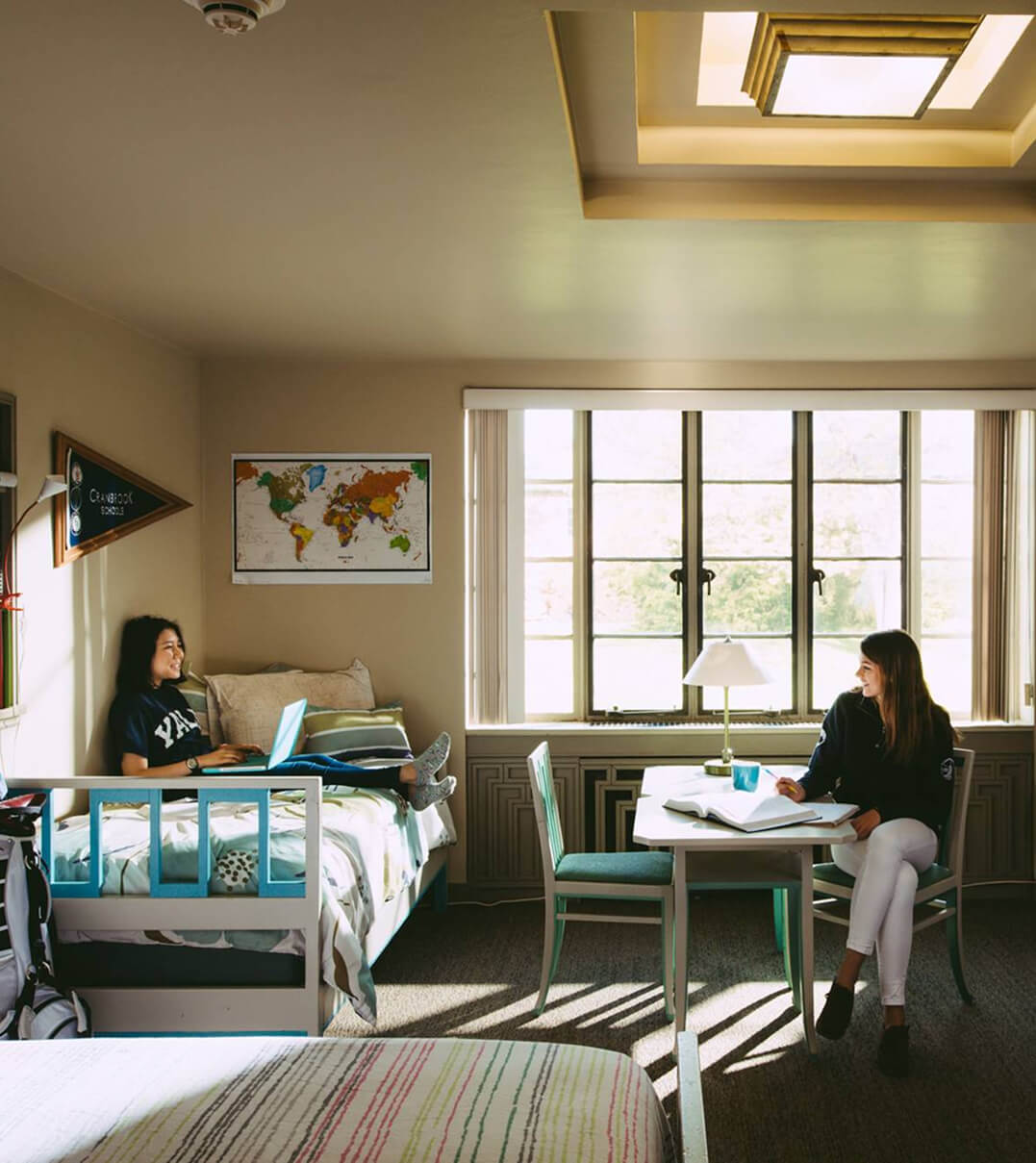 Two Cranbrook Schools students laughing in their dorm room.