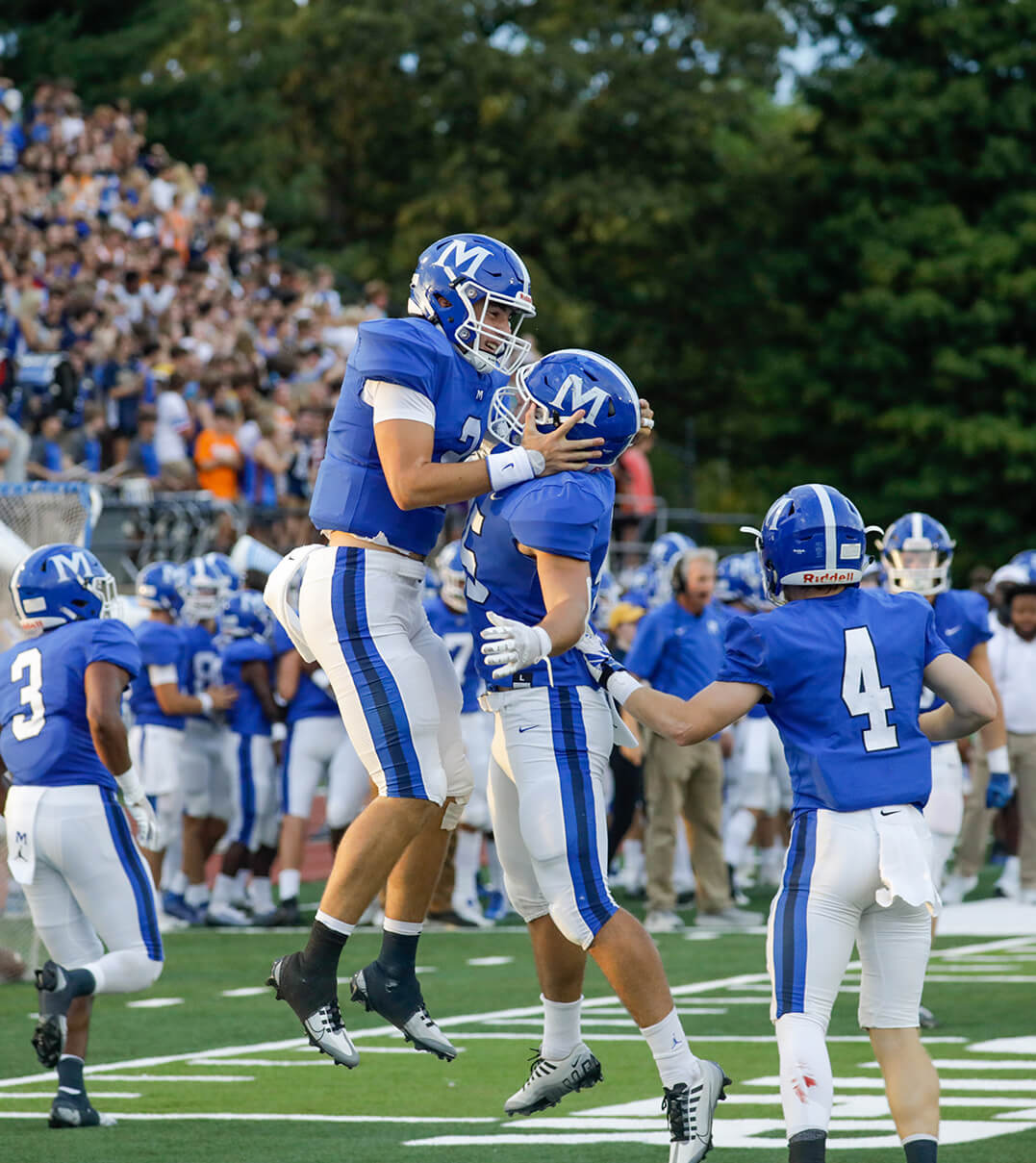 McCallie football players jumping up and celebrating a touchdown.
