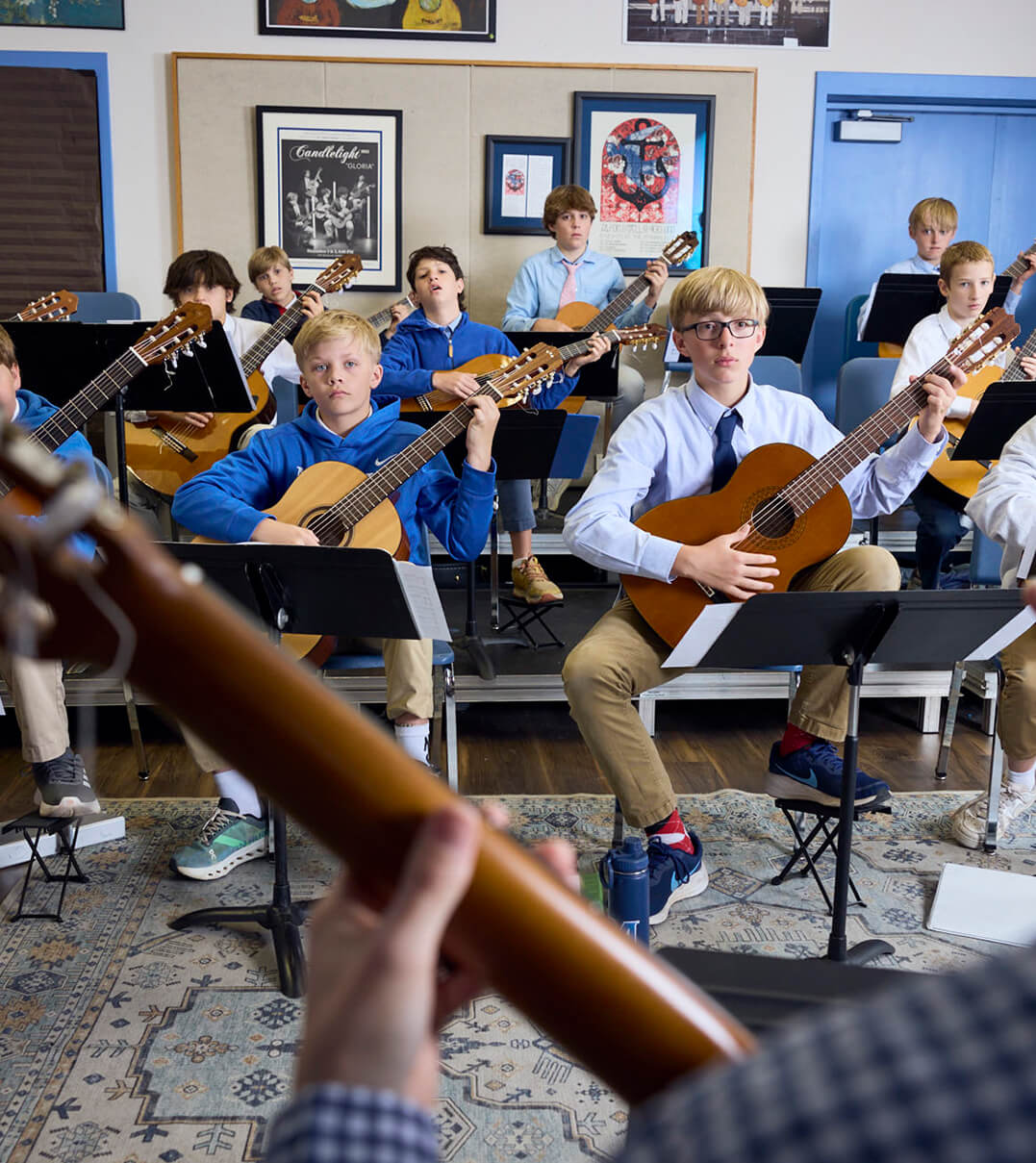 McCallie School students playing guitar during a lesson.