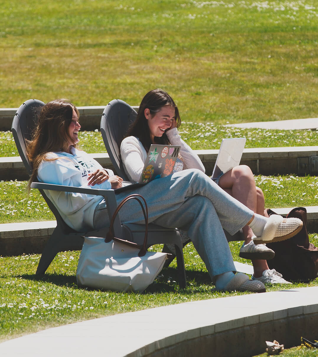 Two Stevenson School students relaxing in Adirondack chairs.