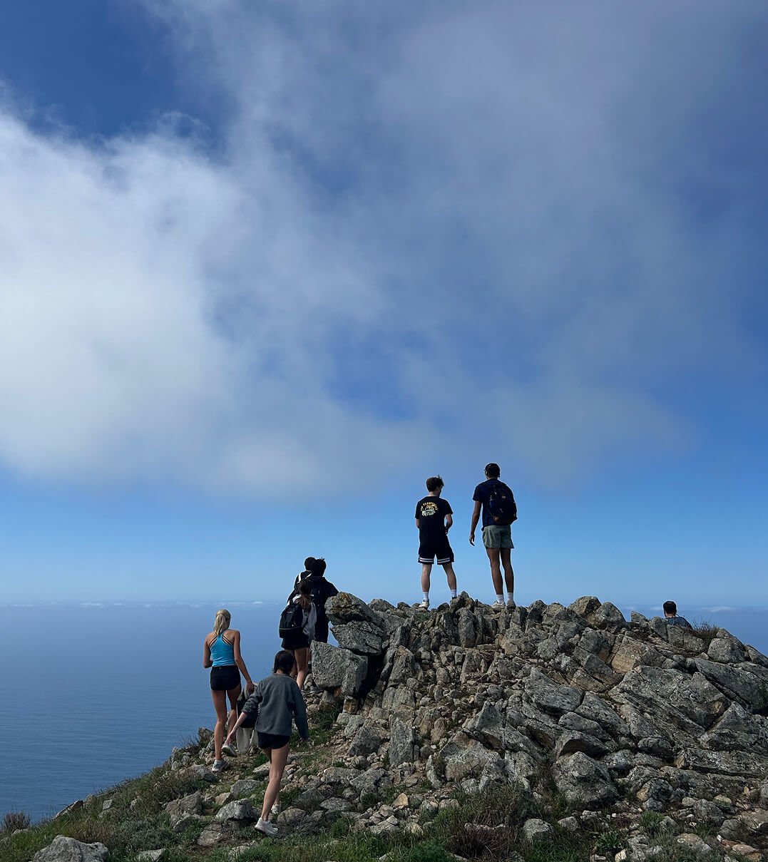 Stevenson School students on a hike at a peak overlooking the ocean.