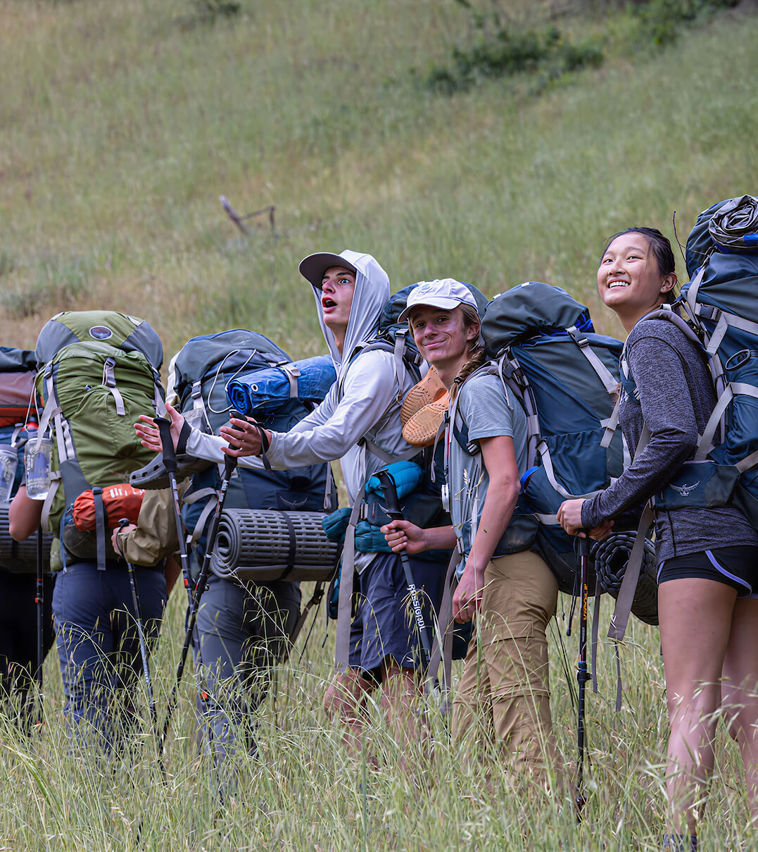 Stevenson School students hiking up a mountain in a line and looking back at the view.