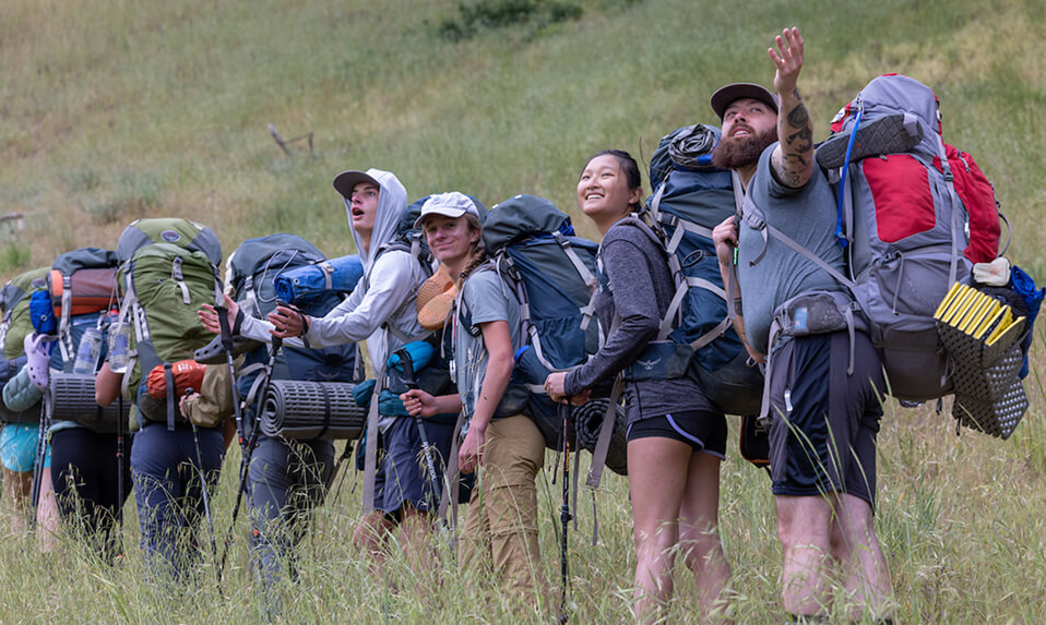 Stevenson School students hiking up a mountain in a line and looking back at the view.