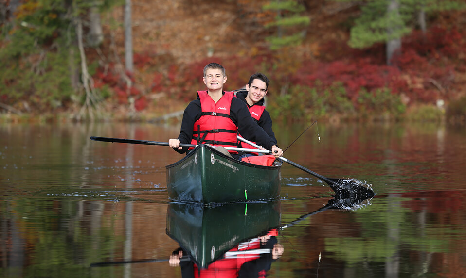 Two Thornton Academy students rowing a canoe.