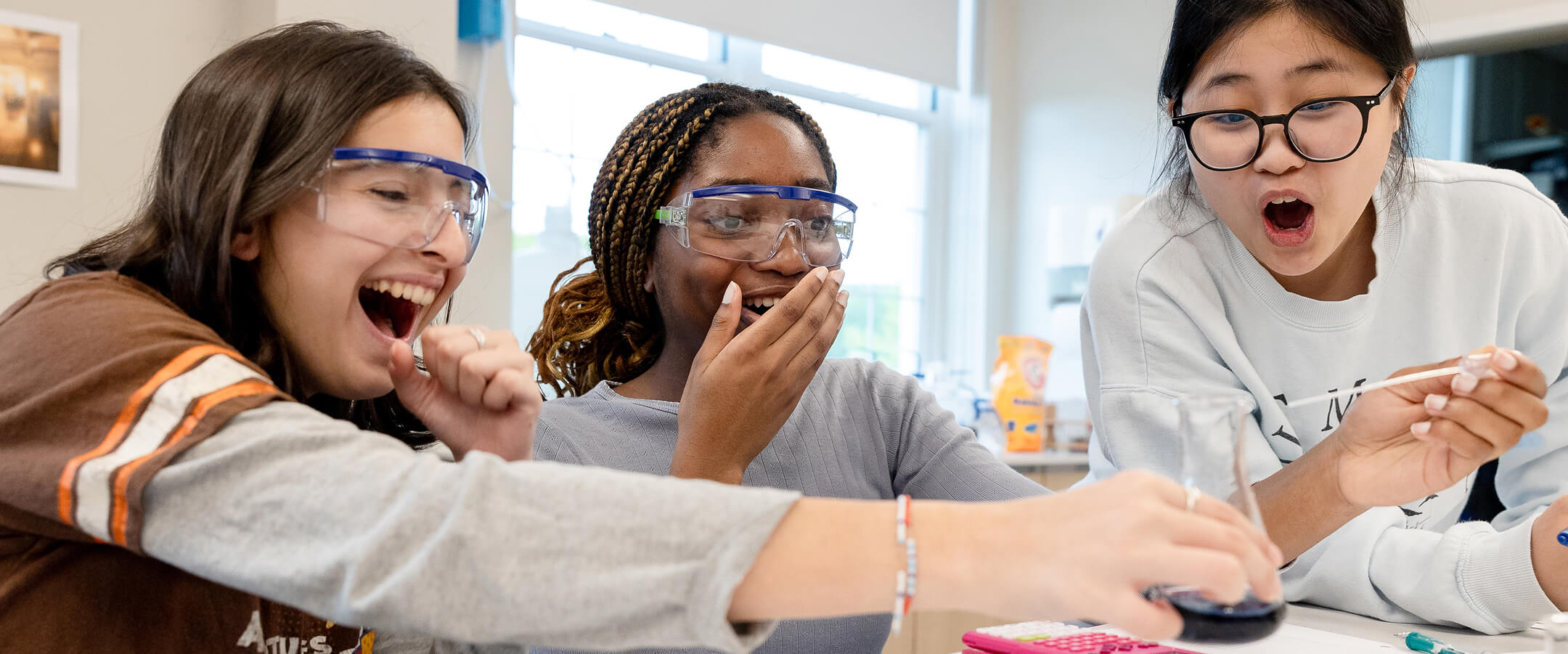 Three Miss Hall's School students conducting a science experiment.