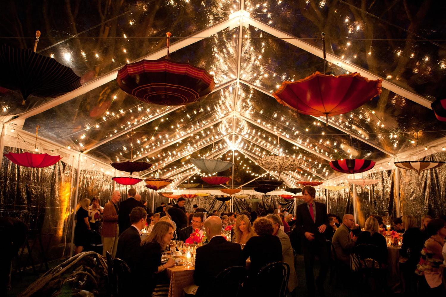 Tented wedding reception glowing warm at night