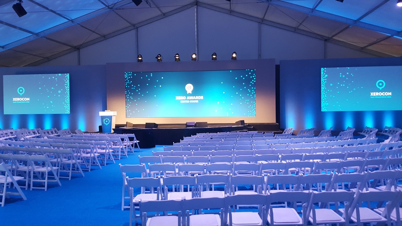 Teal-lit corporate general session