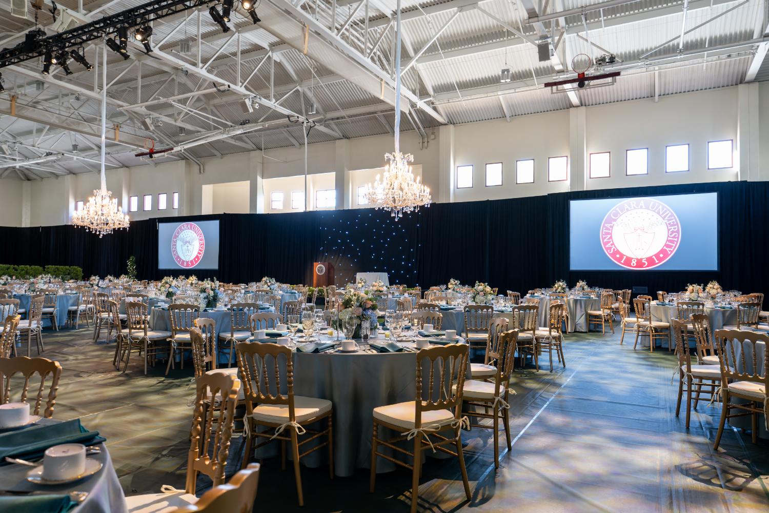 Ballroom gala with chandeliers and twin screens