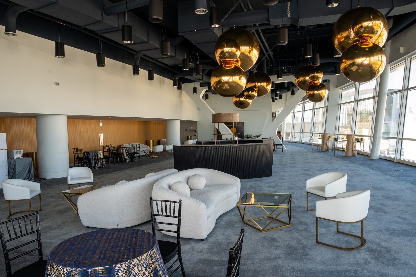 Suspended gold orb installation glowing over a celebration