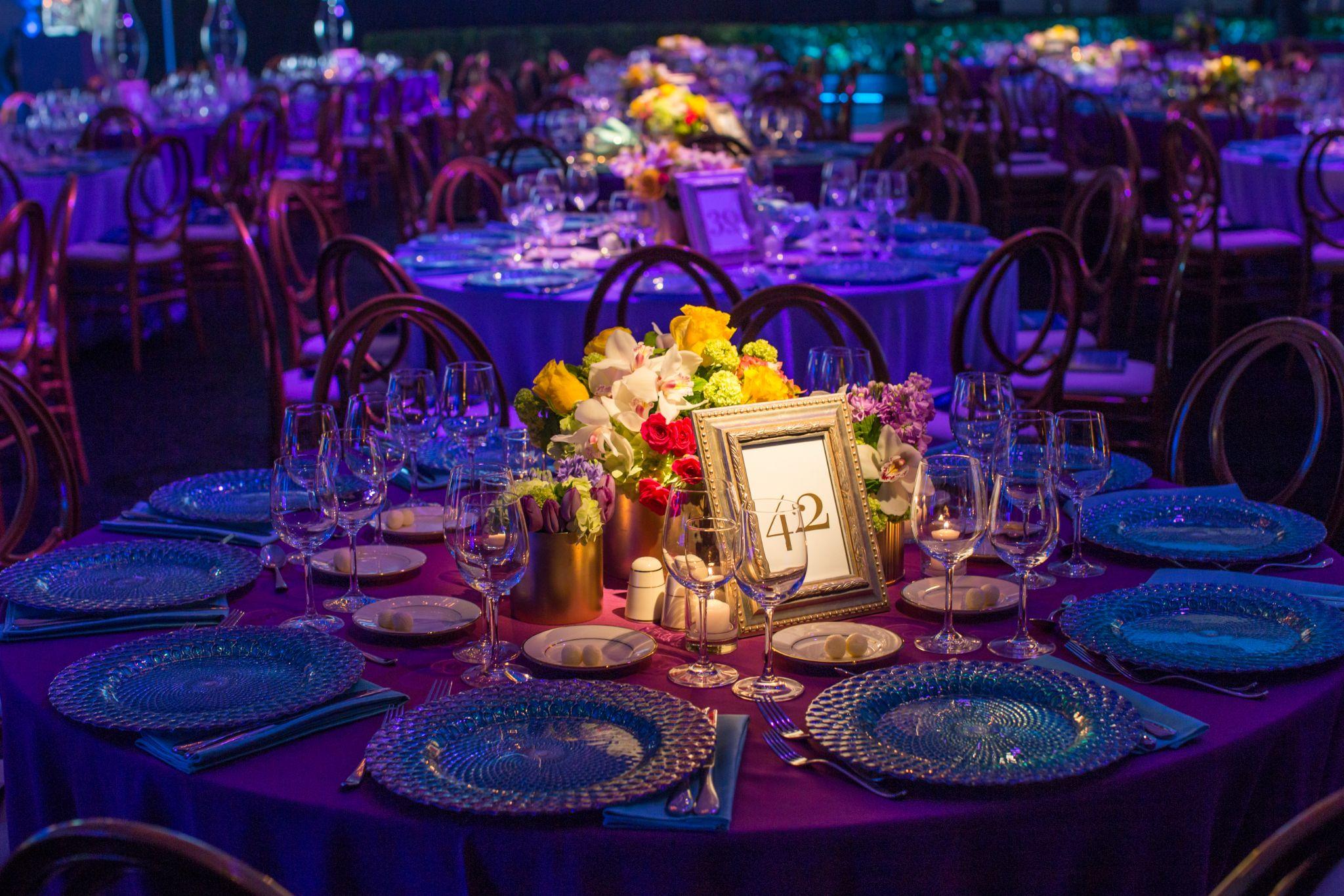 Pin spots illuminating centerpieces on a styled event table