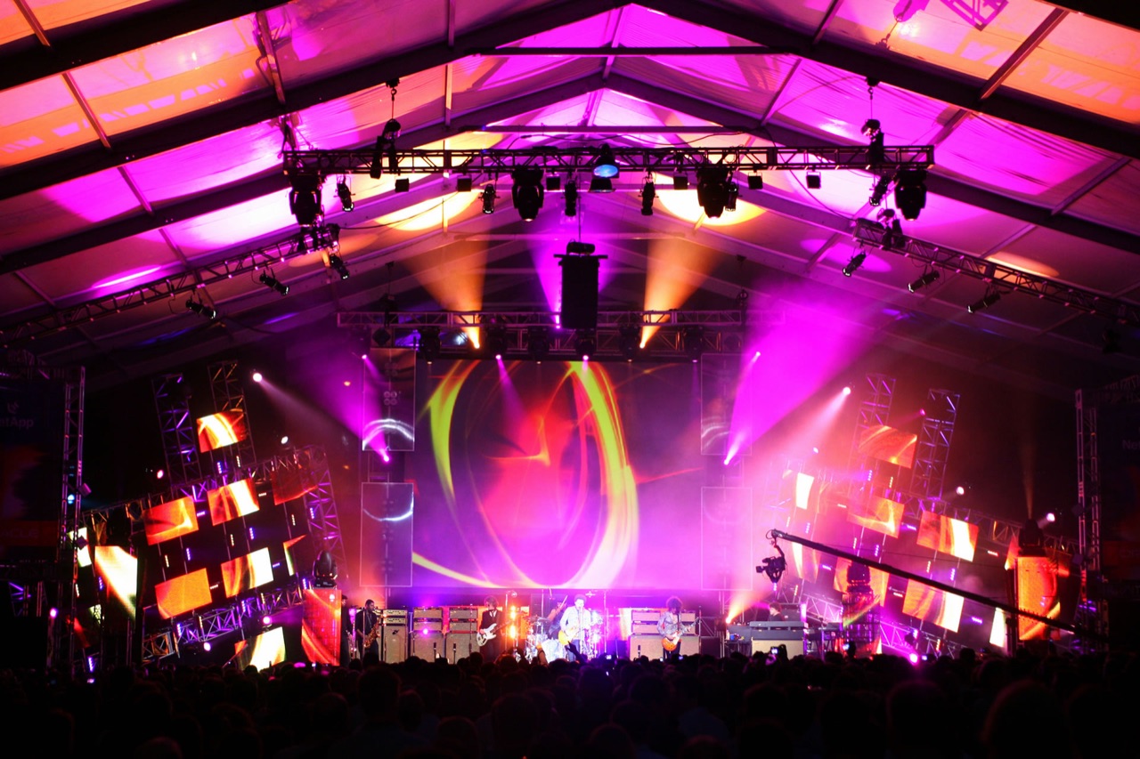 Impact lit a tented concert stage with magenta wash lighting, LED panels, and projected graphics above the crowd.